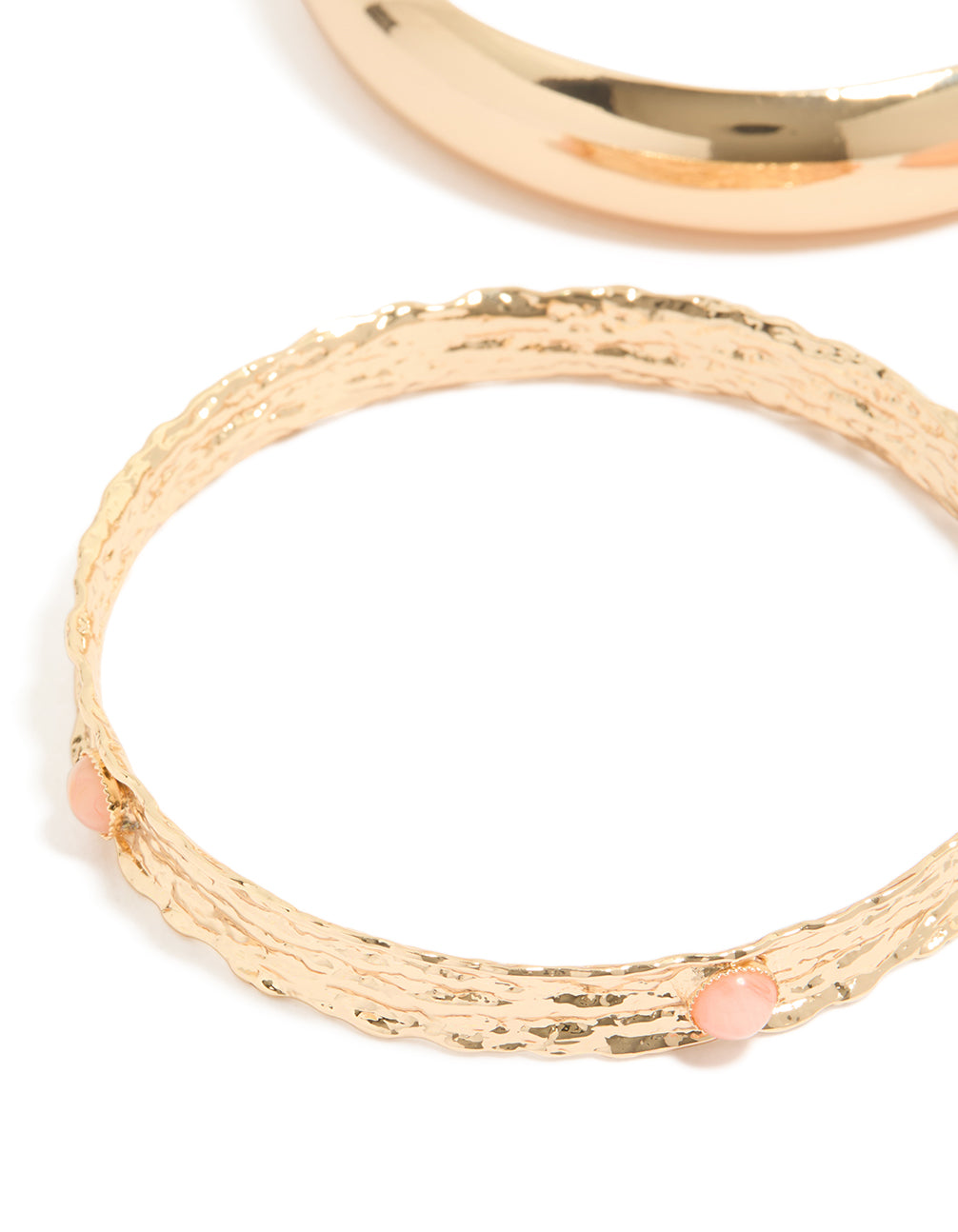 Featuring chunky gold textured and resin bangles in a 3-pack with peachpuff accents close up view