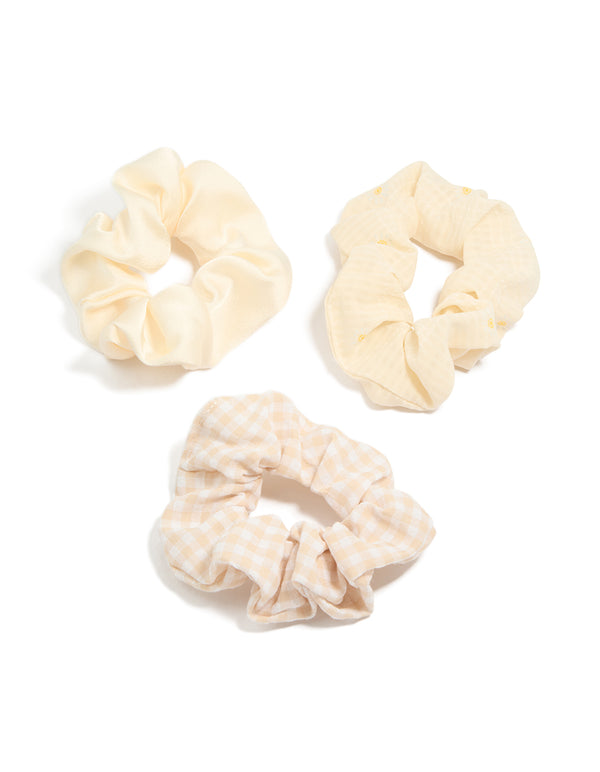 Showcasing a floral checkered 3-pack of cream, white, and yellow scrunchies front view