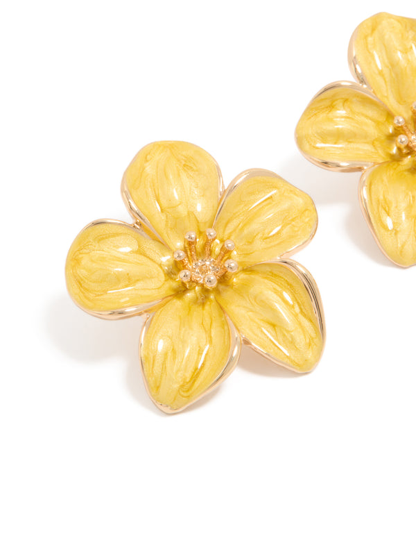 Showcasing statement yellow floral stud earrings with gold accents close up view