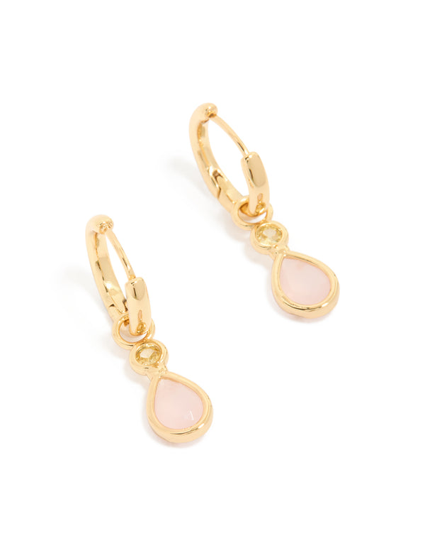 Showcasing statement huggie earrings with pink cubic zirconia teardrop in gold plated finish front view