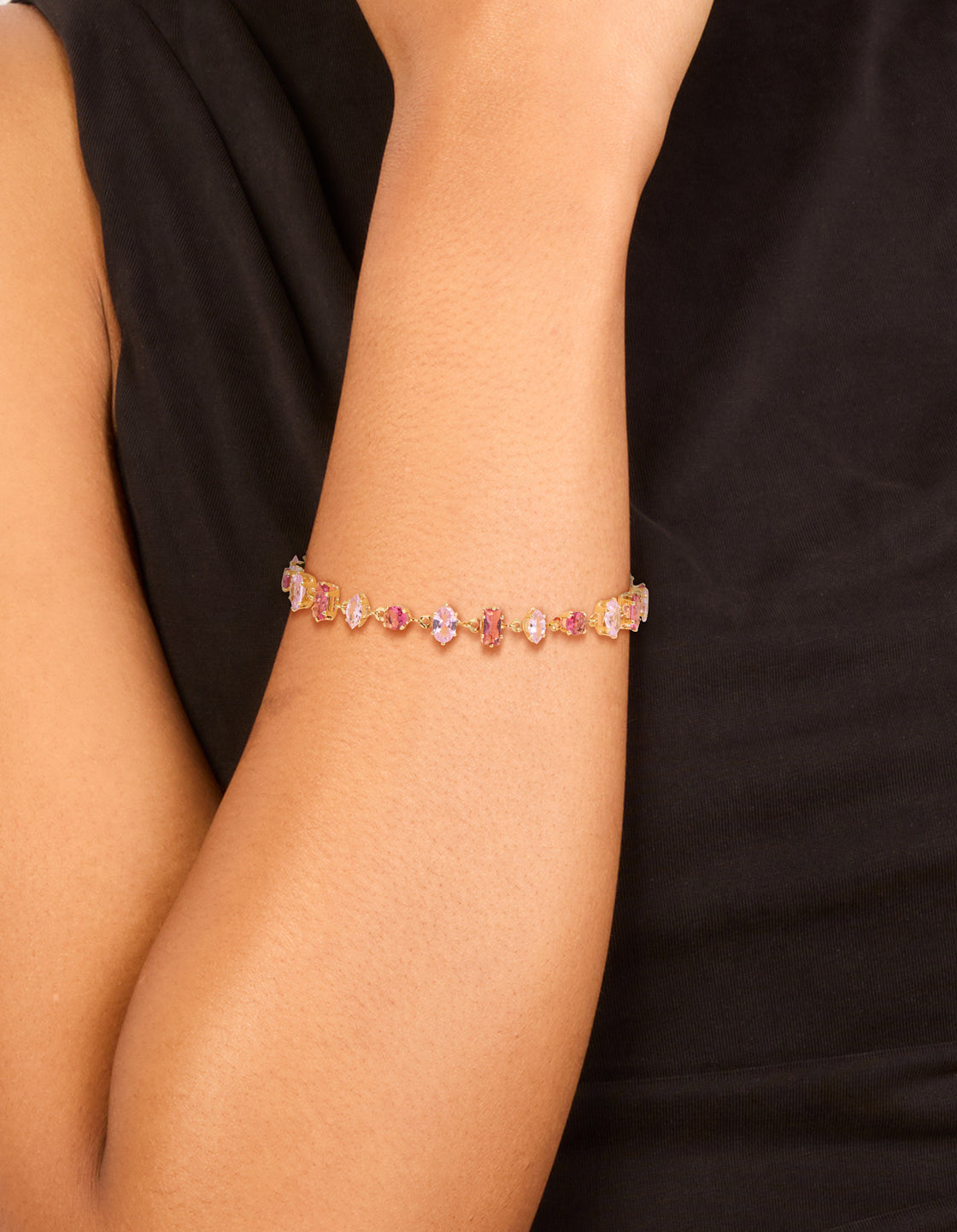 Elegant gold large pink multi-cut cubic zirconia bracelet with hot pink stones on wrist view