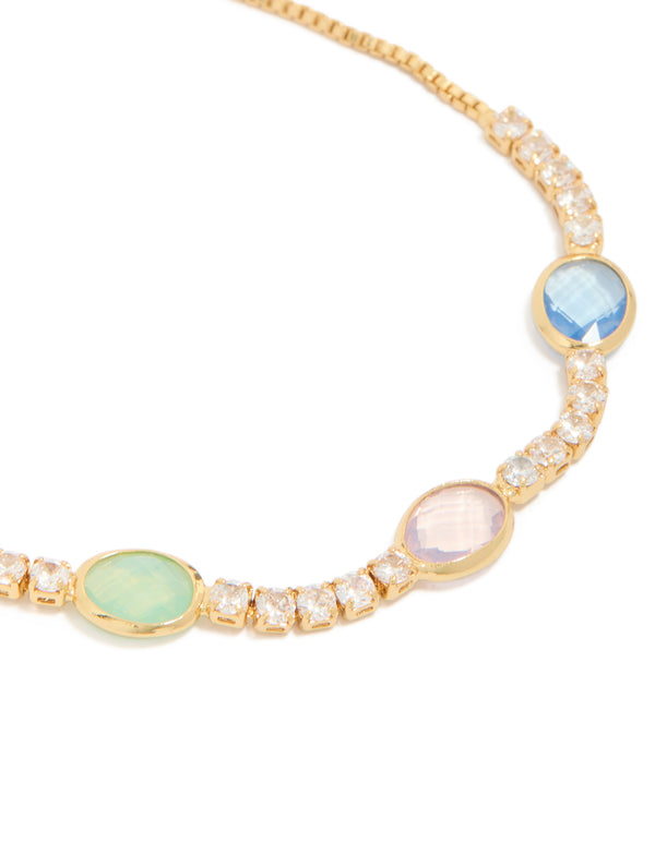 Showcasing bezel toggle bracelet featuring cubic zirconia stones in light sky blue, mint cream and light pink, plated gold, close up view