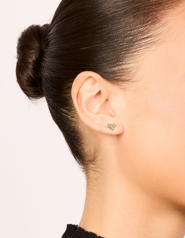 Crafted from gold plated surgical steel, these oval and circle cubic cluster zirconia flat back studs feature clear stones, shown on ear view