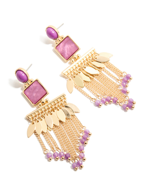 Showcasing gold statement drop earrings with purple beaded chain tassels, and leaf charm accents front view