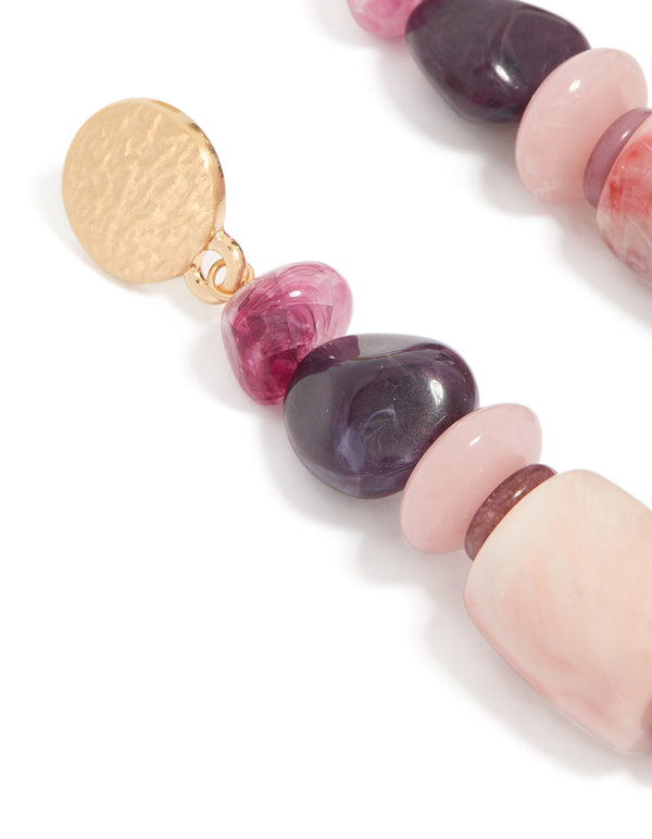Showcasing textured metal disc and colorful beaded detailing on these chunky earrings close up view
