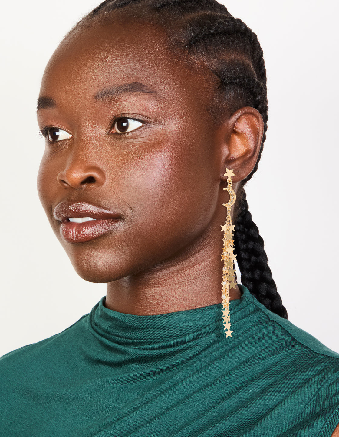 Styled gold star and moon chain drop earrings with celestial charm accents on model view