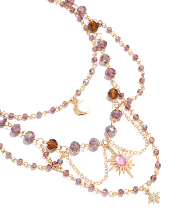 Featuring a gold purple beaded celestial draped layered necklace with charm pendant moon and star close up view