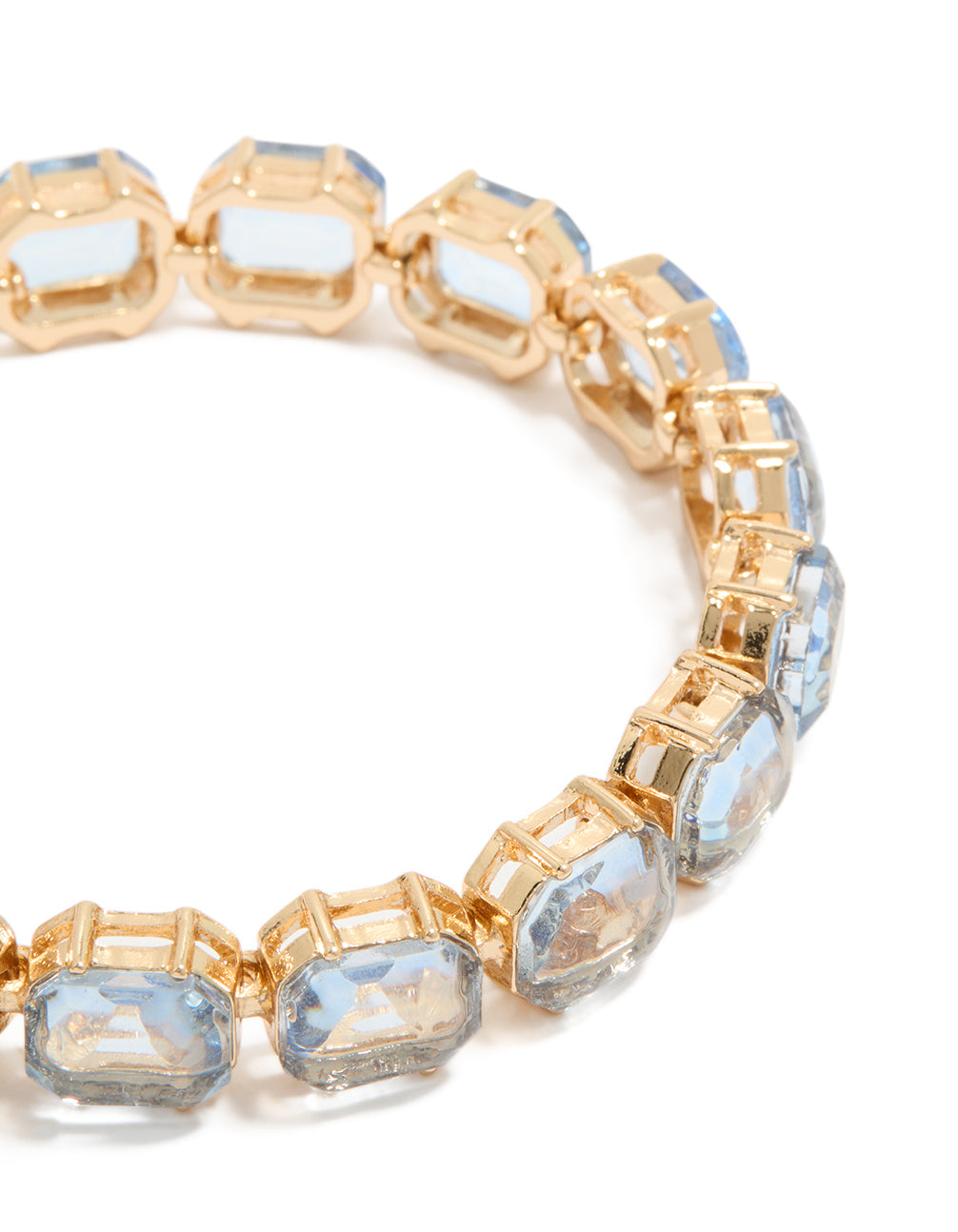 Highlighting a gold large light blue diamantes bracelet close up view