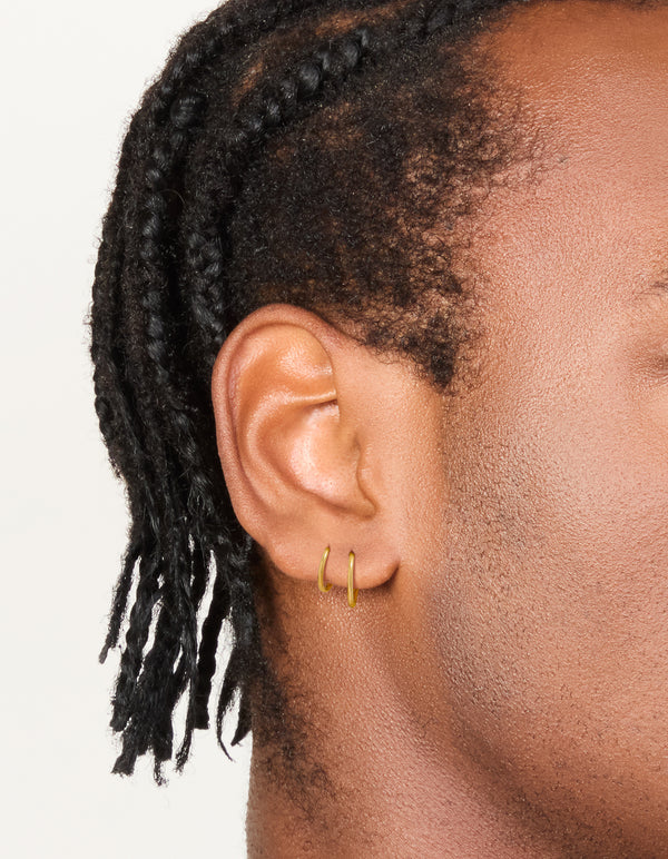 Featuring waterproof gold plated stainless steel mixed size sleeper hoop earrings in a 2-pack on ear view