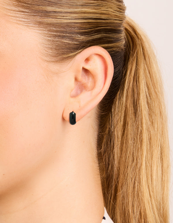 Featuring chunky style, these waterproof black coated stainless steel huggie earrings on ear view