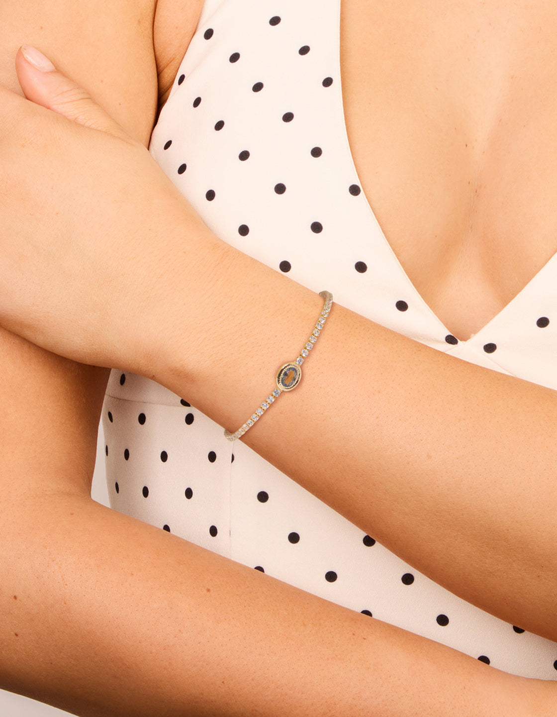 Featuring a gold plated cubic zirconia oval bezel toggle bracelet in teal on wrist view
