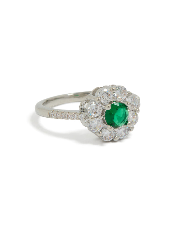 Showcasing a dainty ring with green cubic zirconia center stone and clear floral halo design in silver front view