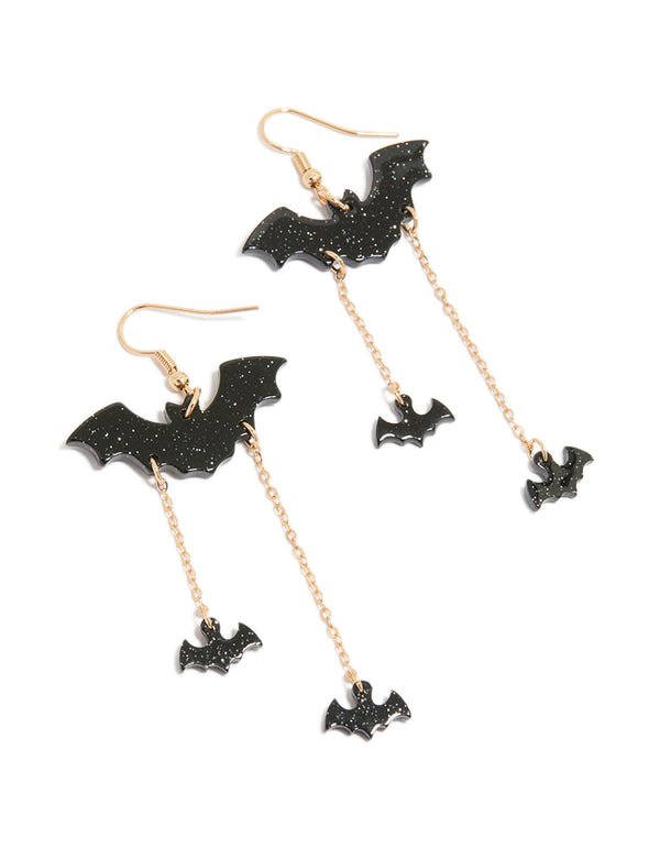 Discover Gold Bat Chain Drop Earrings featuring charm accents with glitter detail in black and gold tones front view