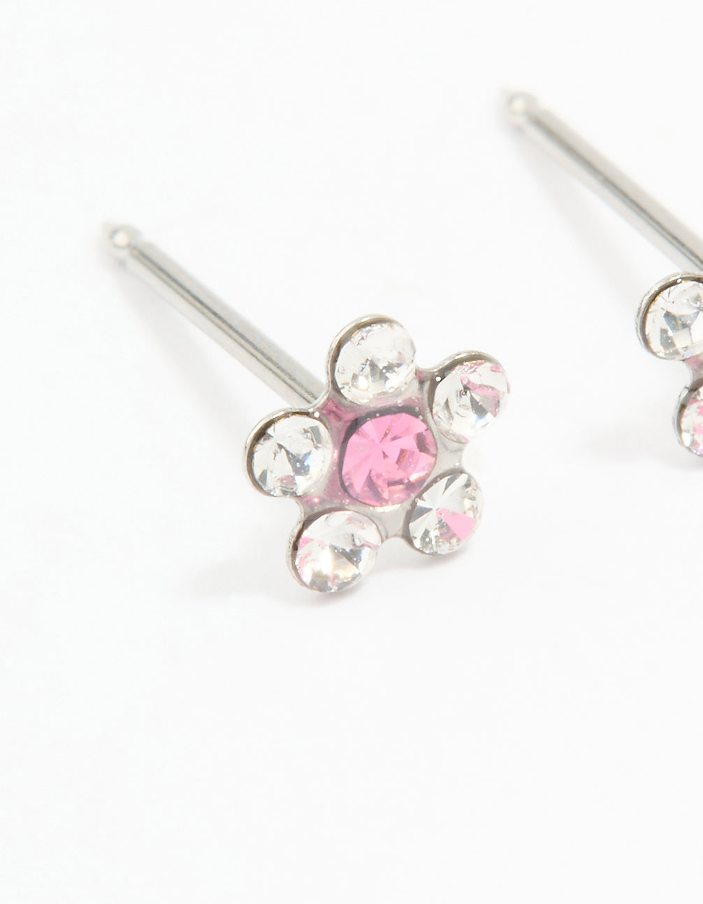 Dainty floral stud piercing earrings featuring pink and clear cubic zirconia set in surgical stainless steel close up view
