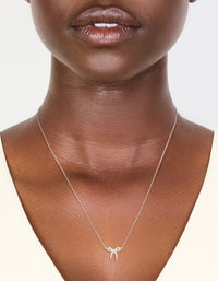 Featuring a sterling silver cubic zirconia bow pendant necklace with dainty on neck view - link has visual effect only