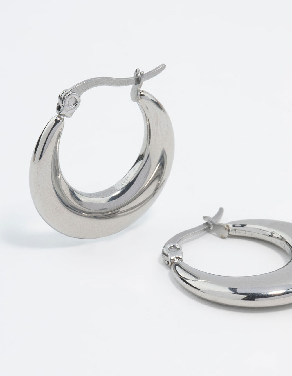 Highlighting waterproof flat crescent hoop earrings crafted from stainless steel in silver close up view