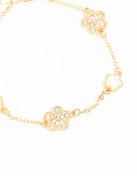 Detailed view of a gold plated alternating small and medium flower bracelet with charm accents in white close up view - link has visual effect only