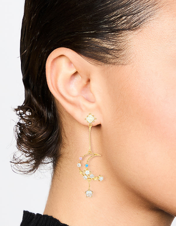 Showcasing gold plated cubic zirconia moon drop earrings with celestial and pearl accents on ear view