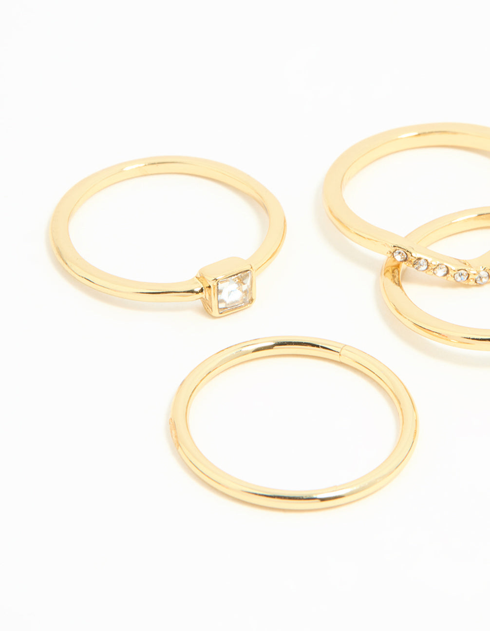 Showcasing square and pear diamante rings 5-pack in gold plated metal with pear stone cut close up view