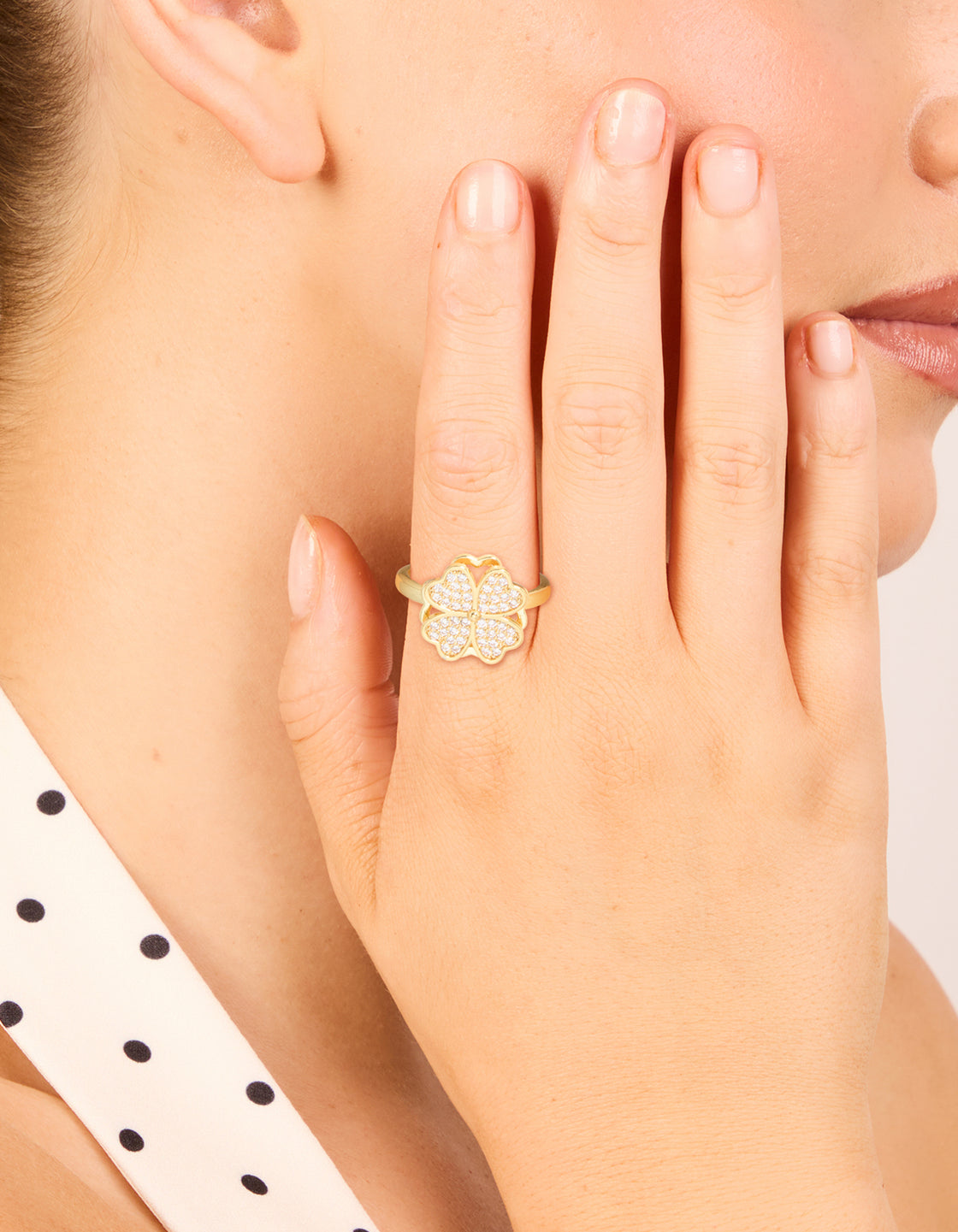 Showcasing a waterproof gold plated stainless steel spinning clover ring with floral and heart in statement style on finger view