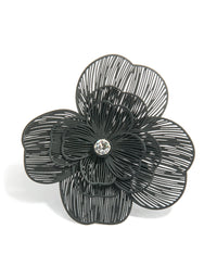 Highlighting a black flower statement ring in silver accents close up view - link has visual effect only