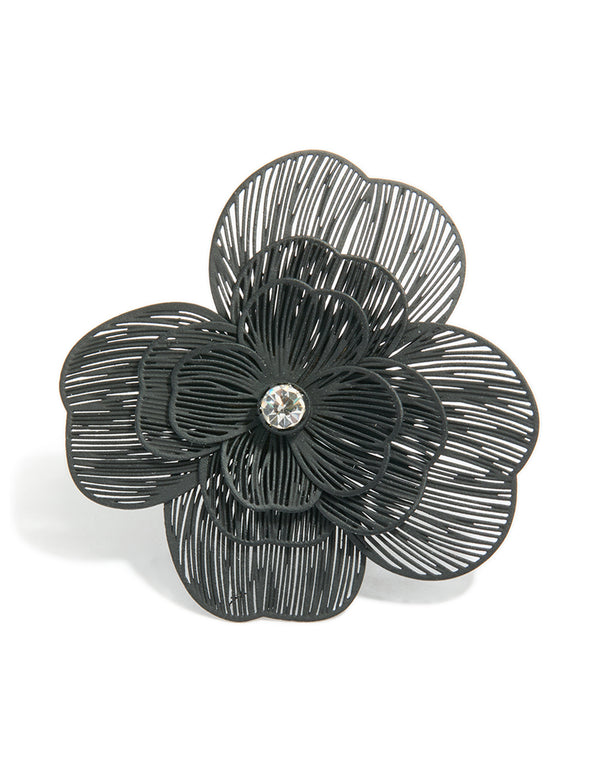 Highlighting a black flower statement ring in silver accents close up view