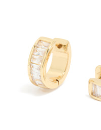 Featuring gold plated cubic zirconia inlay huggie earrings with channel-set baguette stones and closure mechanism close up view - link has visual effect only