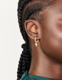Showcasing gold plated cubic zirconia flower pendant huggie earrings in clear stone on ear view - link has visual effect only