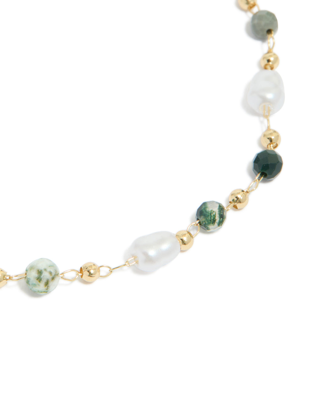 Highlighting a gold plated bracelet with green beads and pearls close up view