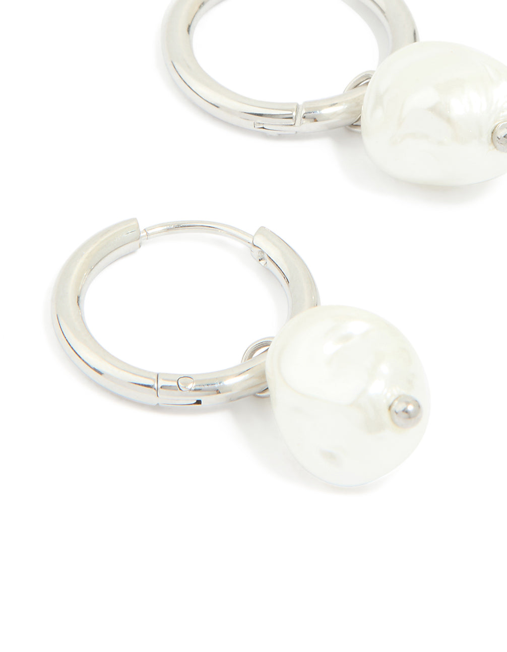 Discover waterproof stainless steel pearl huggie earrings in white and silver close up view