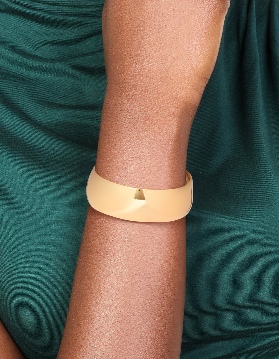 Featuring a waterproof thick open wrist cuff made from stainless steel with statement design in gold plated finish on wrist view