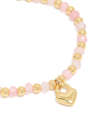 Featuring waterproof gold plated stainless steel bracelet with pink beads and heart charm in light pink close up view - link has visual effect only