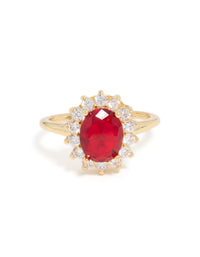 Dazzling statement ring featuring oval cut red cubic zirconia with clear halo stones in gold plated metal close up view - link has visual effect only