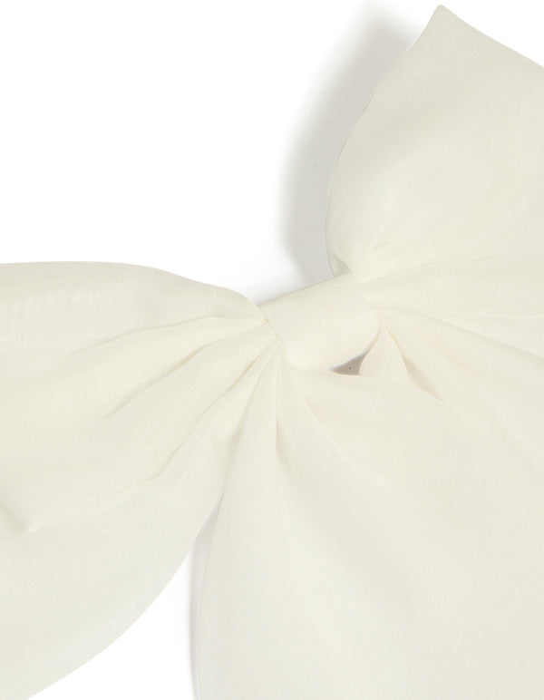 Showcasing a white fabric large bow clip in ivory with solid print detail view