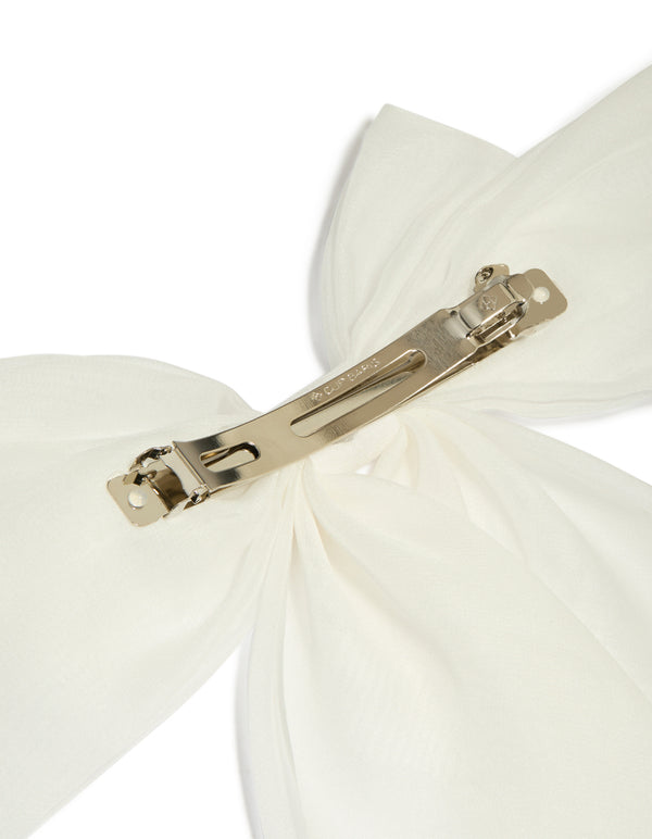 Showcasing a white fabric large bow clip in ivory with solid print detail view