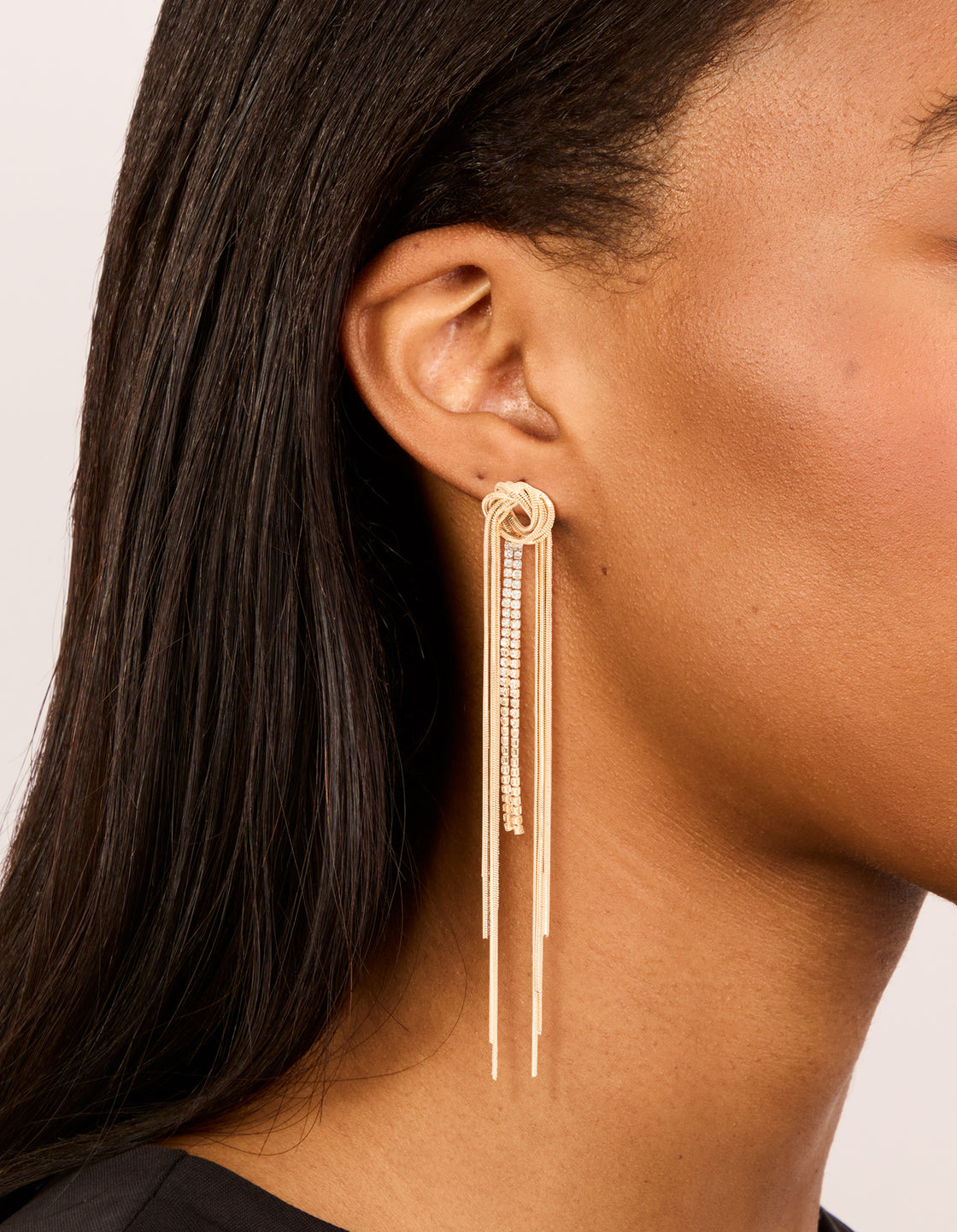 Showcasing gold diamante round tassel drop earrings with statement style side