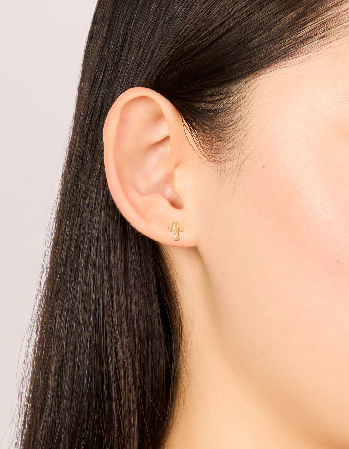 Showcasing waterproof cross stud earrings crafted from stainless steel with cubic zirconia in statement style on ear view