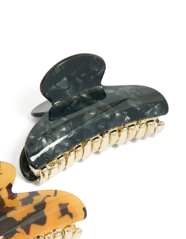 Crafted with tortoiseshell and black acrylic curved claw clips in a 2-pack featuring gold accents side view