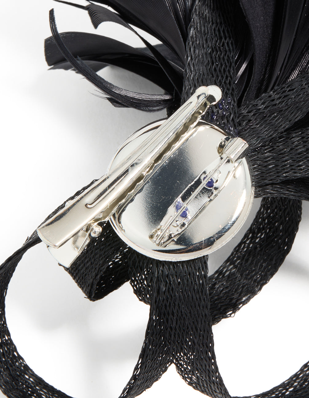 Crafted black loop feather hair clip with silver closure mechanism detail view