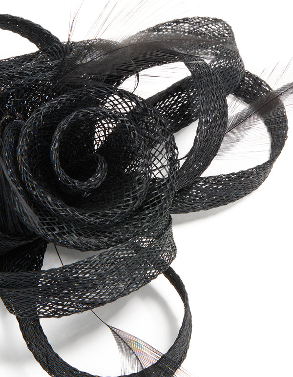 This black sinamay fabric floral hair clip features a swirl and feather design, detail view
