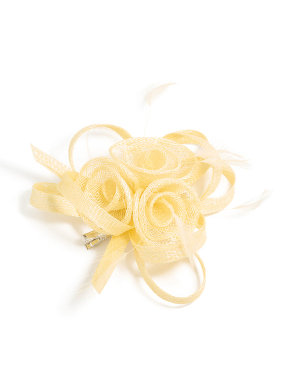 Showcasing a yellow sinamay fabric swirl and feather hair clip with floral design, front view