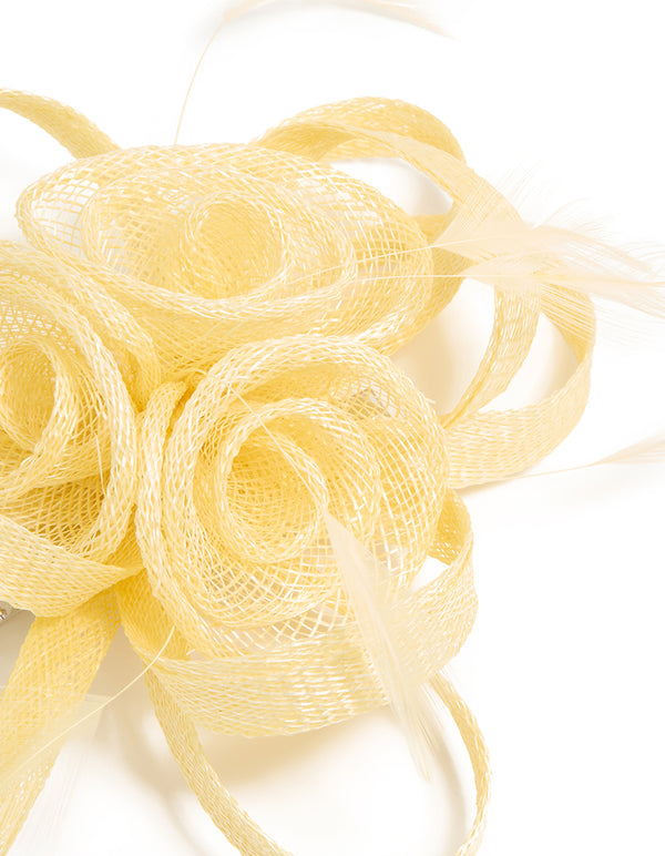 Elegant yellow sinamay fabric swirl and feather hair clip featuring floral accents, side view
