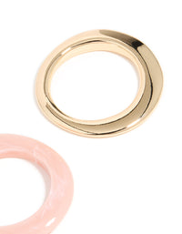 Showcasing a 2-pack of chunky acrylic bangles in gold and pink close up view - link has visual effect only