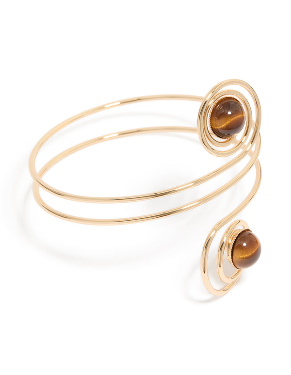 Showcasing a gold swirl and brown stones arm cuff with statement design front view