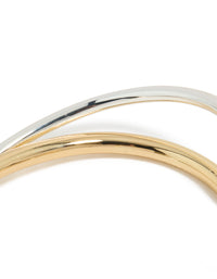Featuring a mixed metal open crossover wrist cuff in gold plated and silver tones designed as a bangle detail view - link has visual effect only