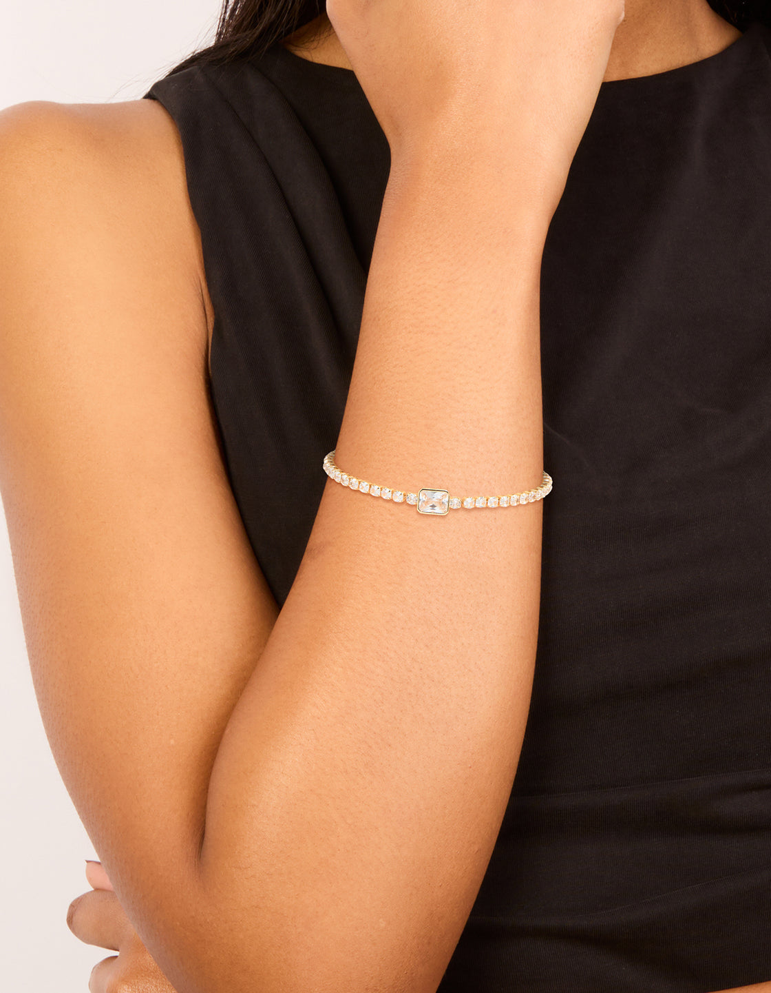 Showcasing a gold plated cubic zirconia rectangle tennis bracelet worn on wrist view