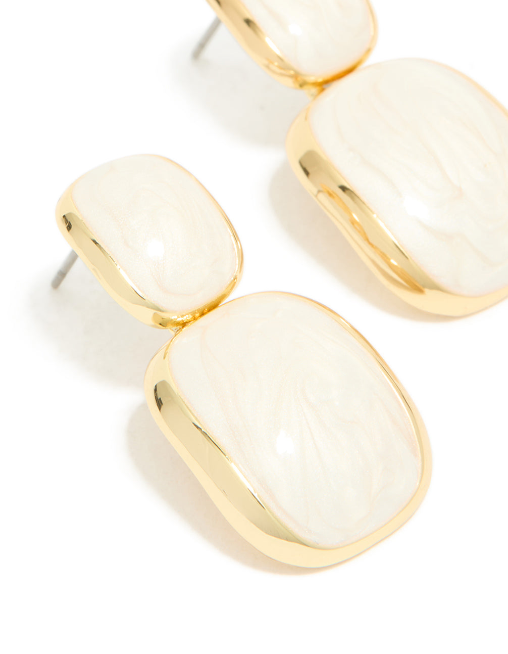 Featuring cream enamel and gold plated construction, statement drop earrings close up view