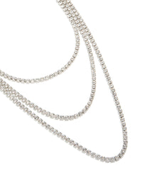 Showcasing a diamante tennis triple layered necklace in silver close up view - link has visual effect only