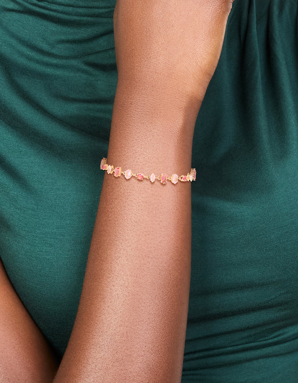 Stunning bracelet featuring light pink and hot pink cubic zirconia in a dainty gold design on wrist view