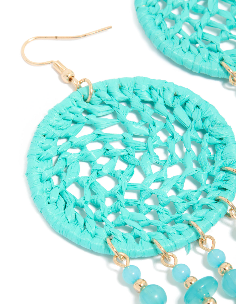 Beautifully crafted dreamcatcher drop earrings featuring light blue fabric with charm, beads, feathers in turquoise, aqua, and gold close up view
